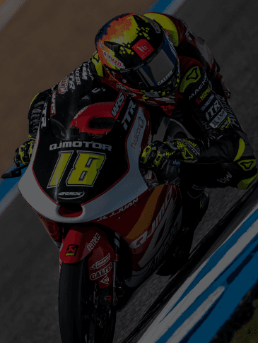 A dynamic shot of a motorcycle racer in full gear leaning into a sharp turn on a racetrack, with blurred motion effects emphasizing speed and precision.